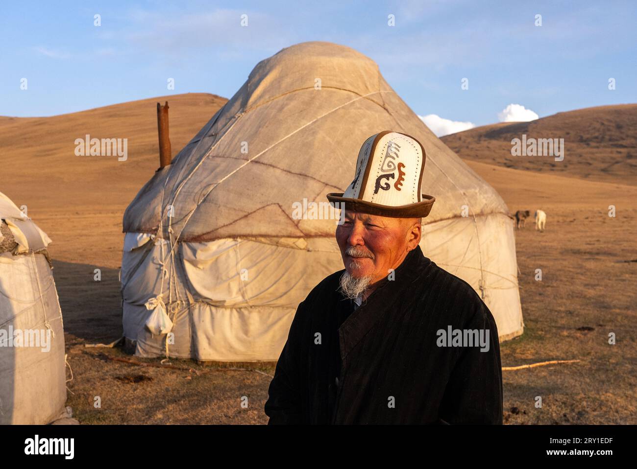 Kyrgyz uomo in abito tradizionale vicino alla sua yurta kyrgyzstan Foto Stock