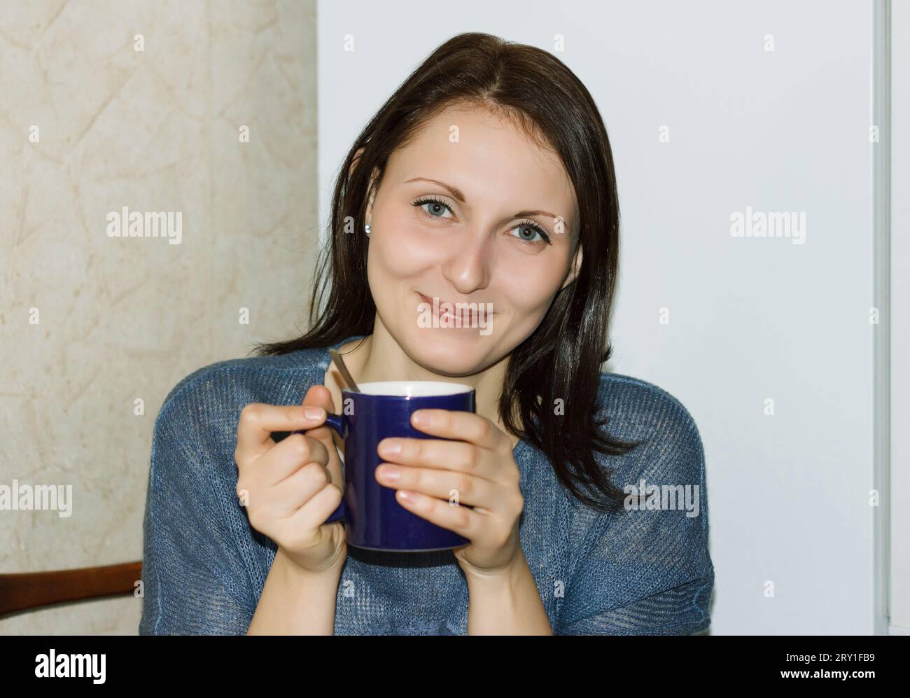 Felice bruna che beve tè caldo in cucina Foto Stock