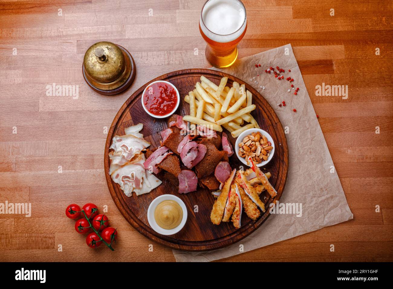 Ampia scelta di spuntini per birra o alcol e include carne di maiale affumicata, patatine fritte, pane fritto, bastoncini di granchio e noci servite con salse su legno Foto Stock