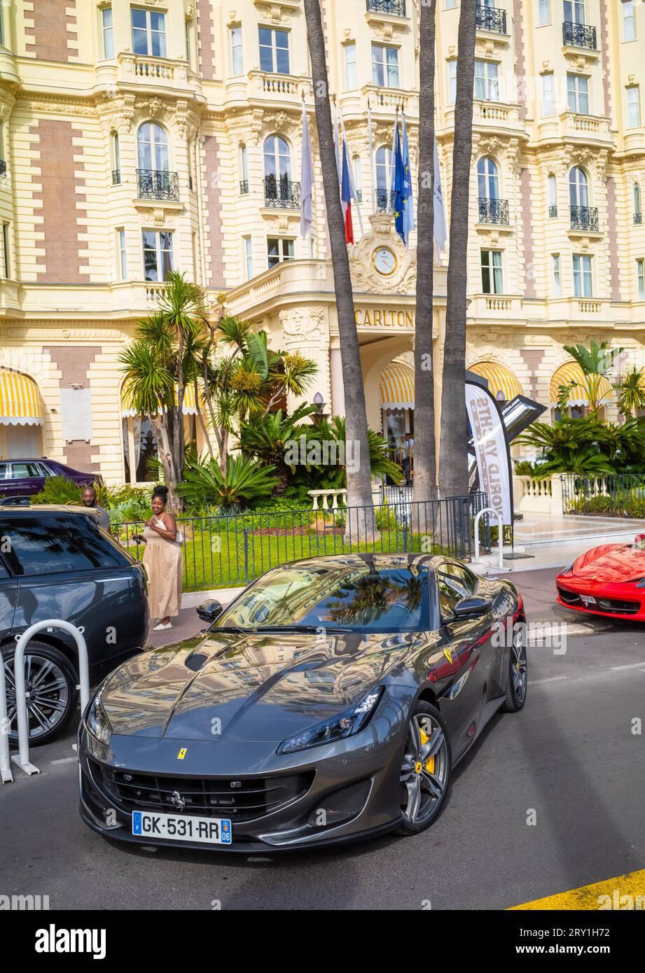 Un'auto sportiva Ferrari grigia esce di fronte al lussuoso Carlton Hotel situato sul Boulevard de la Croisette, direttamente di fronte al Mediterraneo Foto Stock