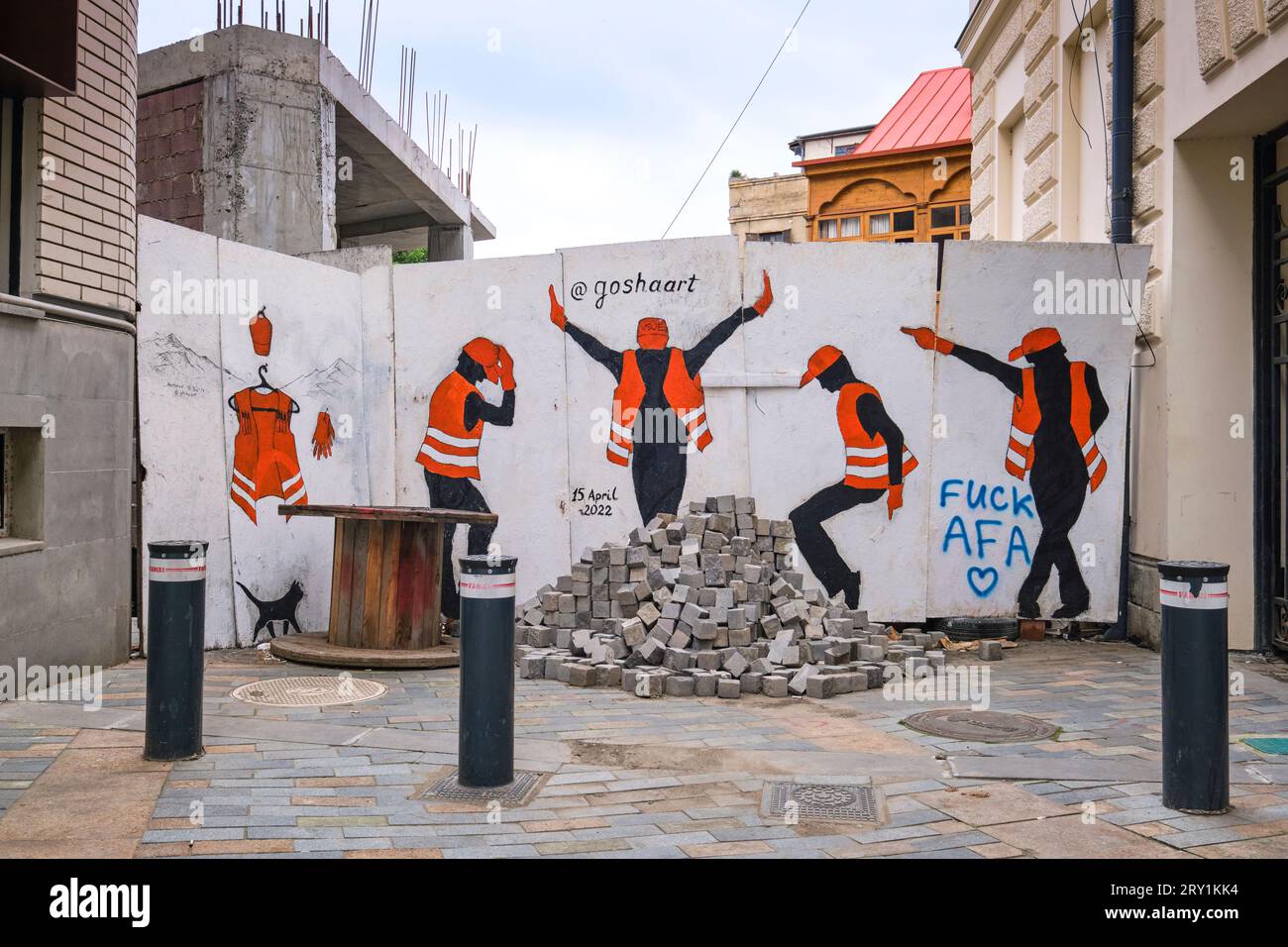 Una recinzione di costruzione con una serie di operai in giubbotti arancioni, che fanno varie pose da ballo da Michael Jackson. Uno dei tanti pubblici, Street art, gra Foto Stock