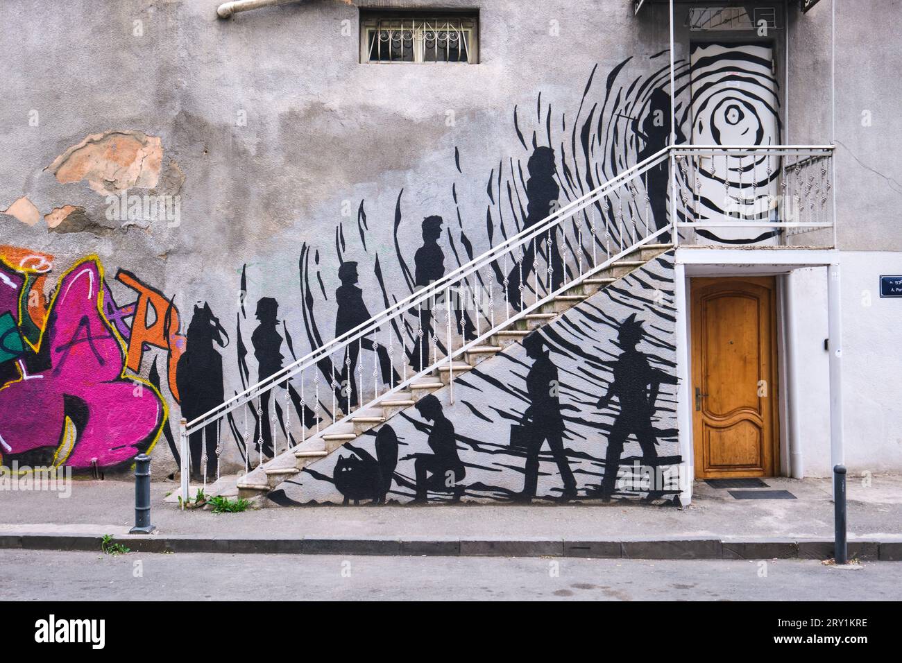Un grande murale su un edificio, raffigurante un gruppo divertente di persone che sale le scale per raggiungere un club. C'è un cavallo, un gatto, un punk e altre persone. A Tbilisi, GE Foto Stock