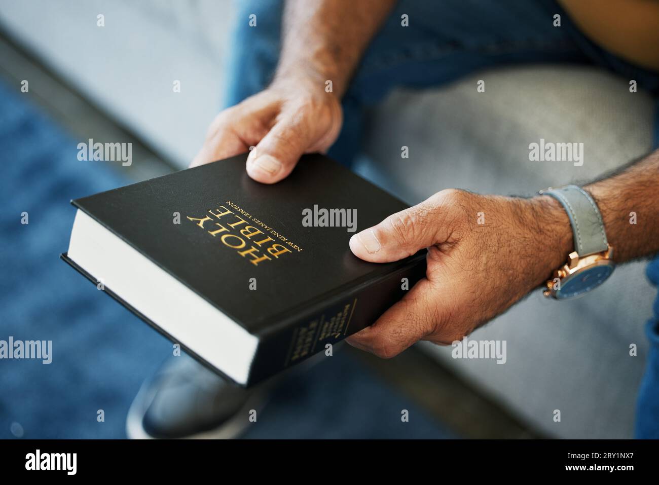 Bibbia, libro e mani dell'uomo in casa con studio della fede cristiana, della religione o della spiritualità. Santo, adorazione e persona con il Vangelo Foto Stock