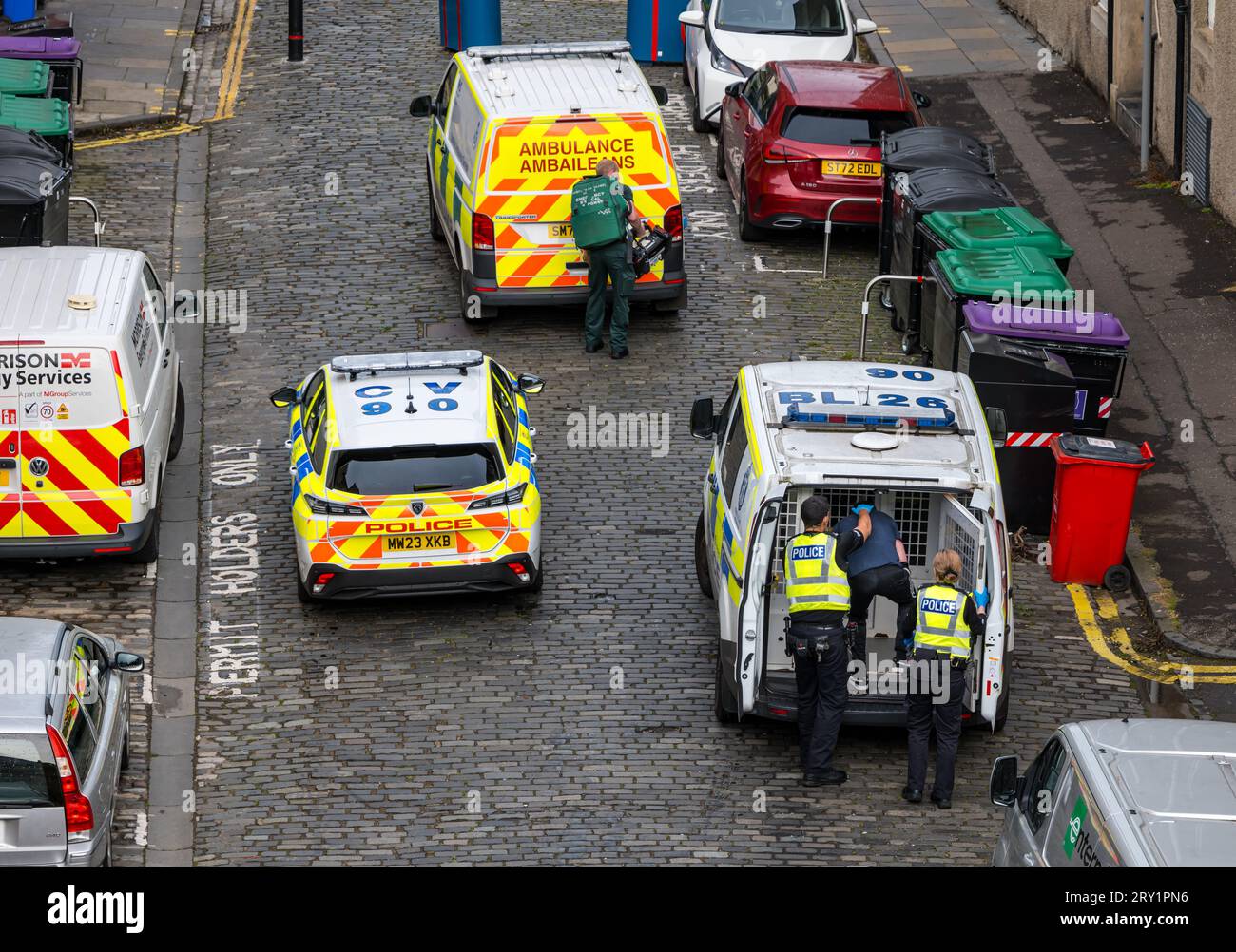 Gli agenti di polizia arrestano un uomo e lo rinchiudono in un furgone della polizia, Leith, Edimburgo, Scozia, Regno Unito Foto Stock