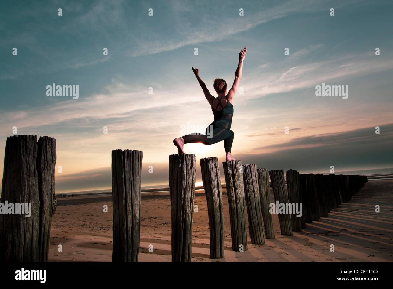 Donna sportiva che fa yoga in riva al mare Foto Stock