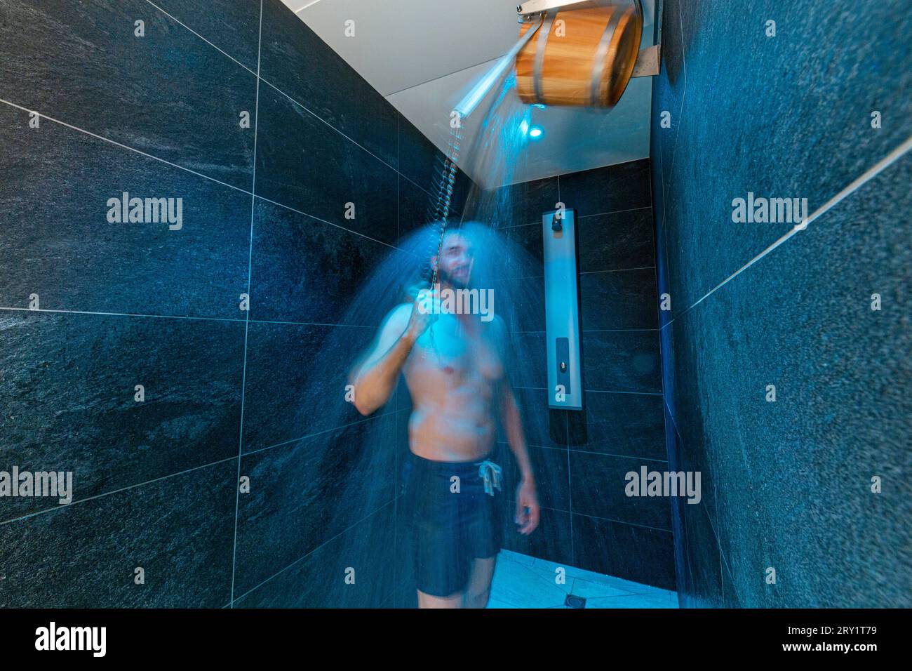 Benessere, spa, un uomo si versa acqua fredda dopo una sauna Foto Stock