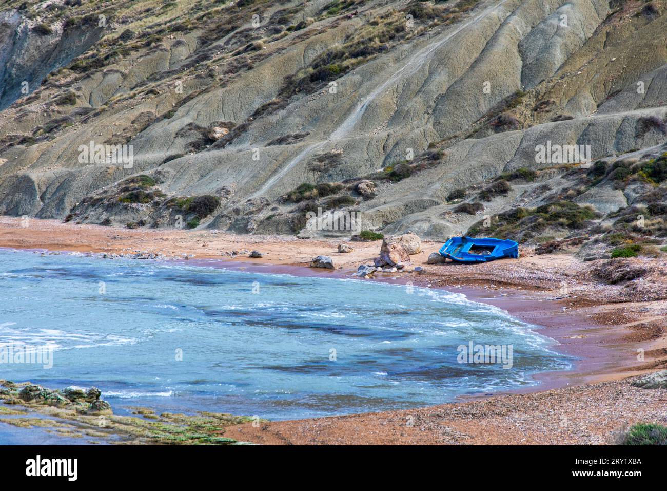 Europa, Italia, Sicilia, barca migrante abbandonata dipinta di blu su una spiaggia Foto Stock
