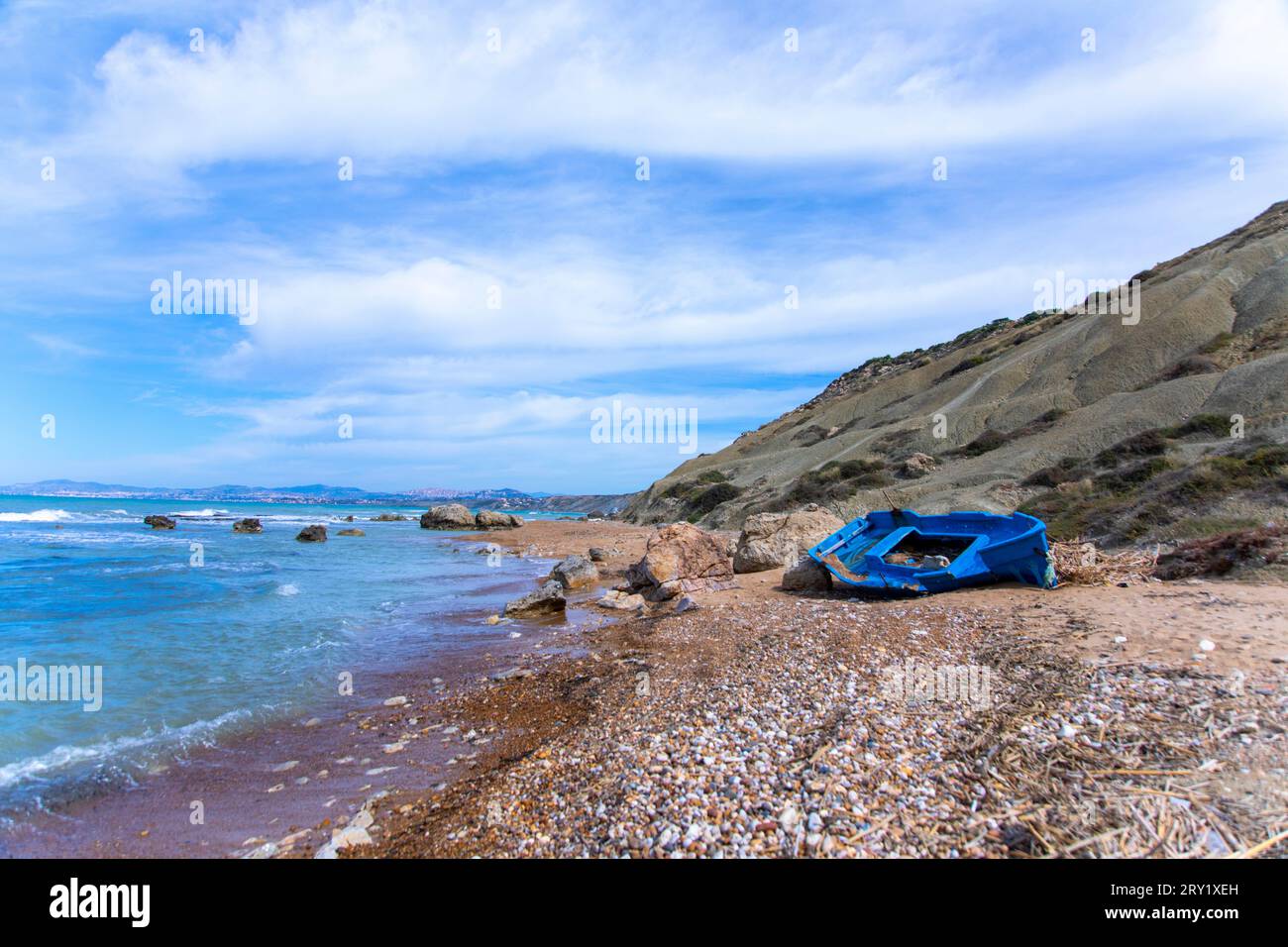 Europa, Italia, Sicilia, barca migrante abbandonata dipinta di blu su una spiaggia Foto Stock