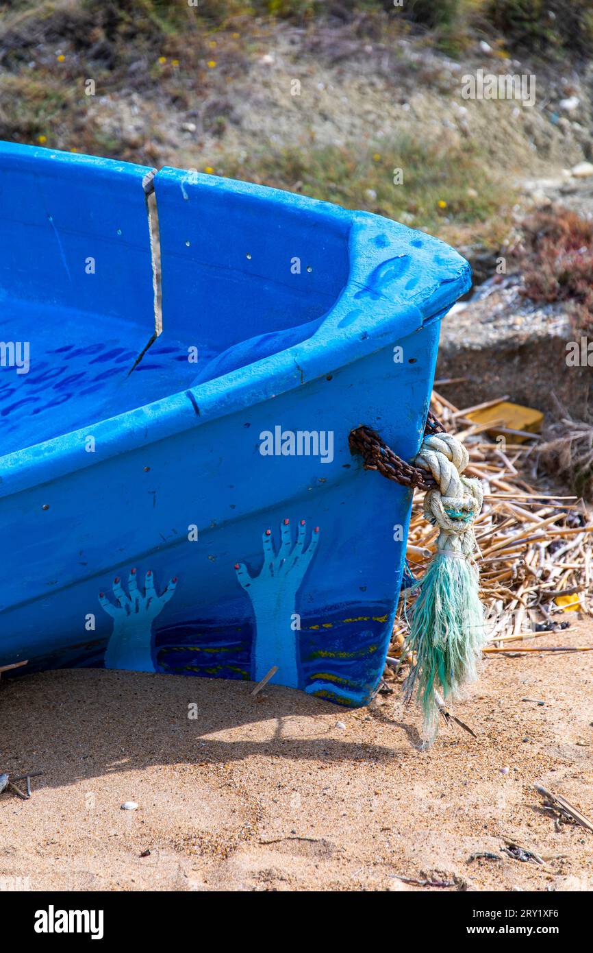 Europa, Italia, Sicilia, barca migrante abbandonata dipinta di blu su una spiaggia Foto Stock