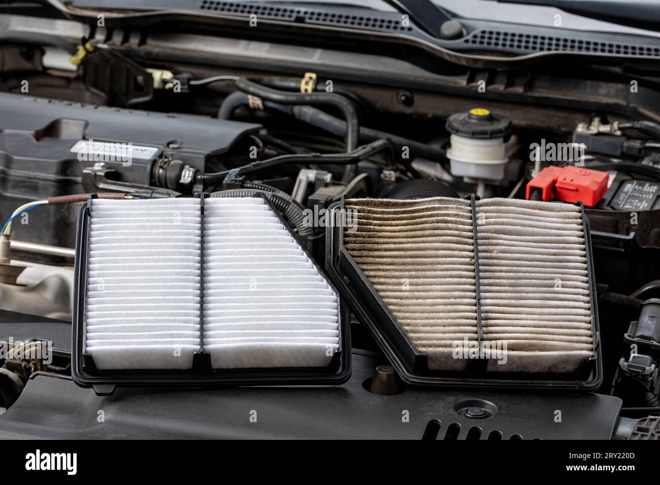 Filtro dell'aria sporco nuovo e vecchio affiancato sul motore del veicolo. Concetto di riparazione, manutenzione, assistenza e chilometraggio del carburante nel settore automobilistico Foto Stock