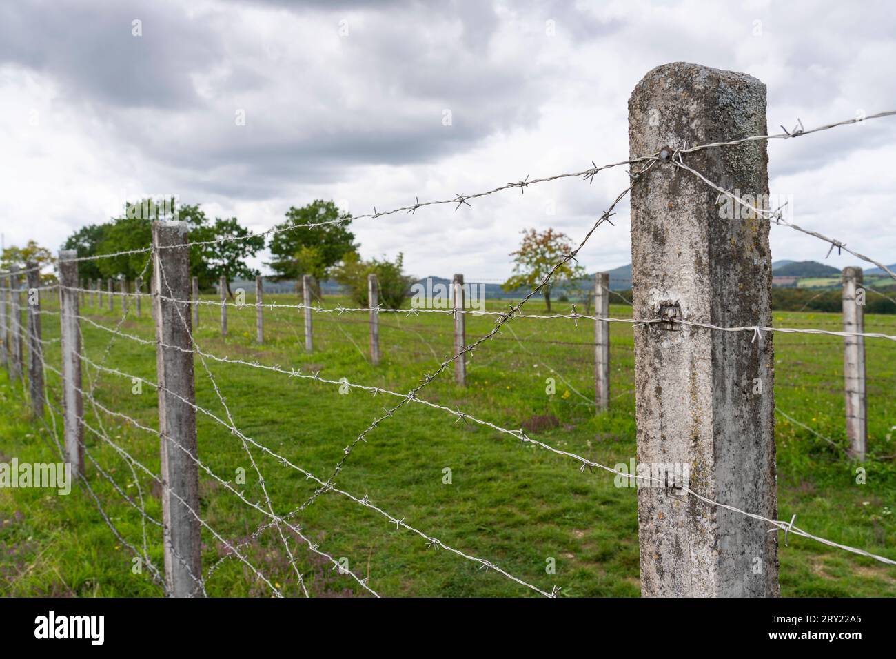 Die Minensperre der ehemaligen DDR-Grenzanlage AM Point Alpha an der ehemaligen Grenze zwischen DDR und BRD bei Geisa Wartburgkreis in der Rhön. Zwischen den beiden Stacheldrahtzäunen befanden sich im Boden vergrabene Antipersonenminen. *** La barriera mineraria dell'ex installazione di frontiera della RDT al punto Alpha, sul confine tra la RDT e la FRG vicino a Geisa Wartburgkreis, nella regione di Rhön, tra le due recinzioni di filo spinato, erano sepolte mine antiuomo nel terreno Foto Stock