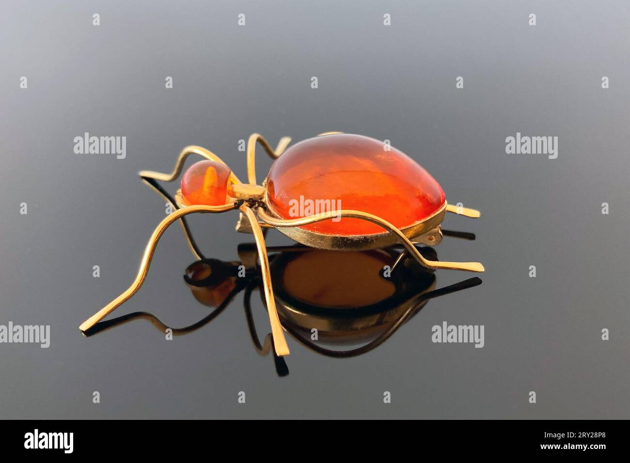 Spilla vintage "Ant" con ambra e ottone, realizzata in URSS su sfondo lucido scuro Foto Stock