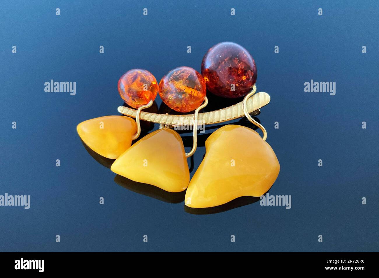 Bacche di spilla vintage e foglie di ambra e ottone, realizzate in URSS su sfondo lucido scuro Foto Stock