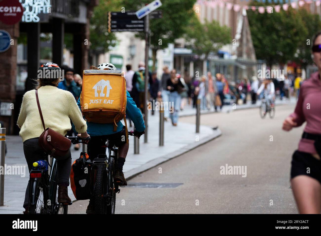 Basta mangiare un ciclista a consegna a domicilio a Exeter High Street Foto Stock