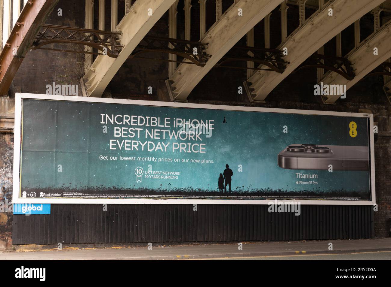Annuncio per iPhone 15 Pro Titanium su rete EE sotto il ponte ferroviario vittoriano Deansgate, Manchester, Regno Unito. Foto Stock