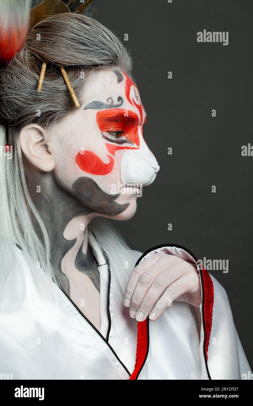 Trucco di Halloween. Donna carina con trucco e costume in stile asiatico, bel primo piano del viso Foto Stock