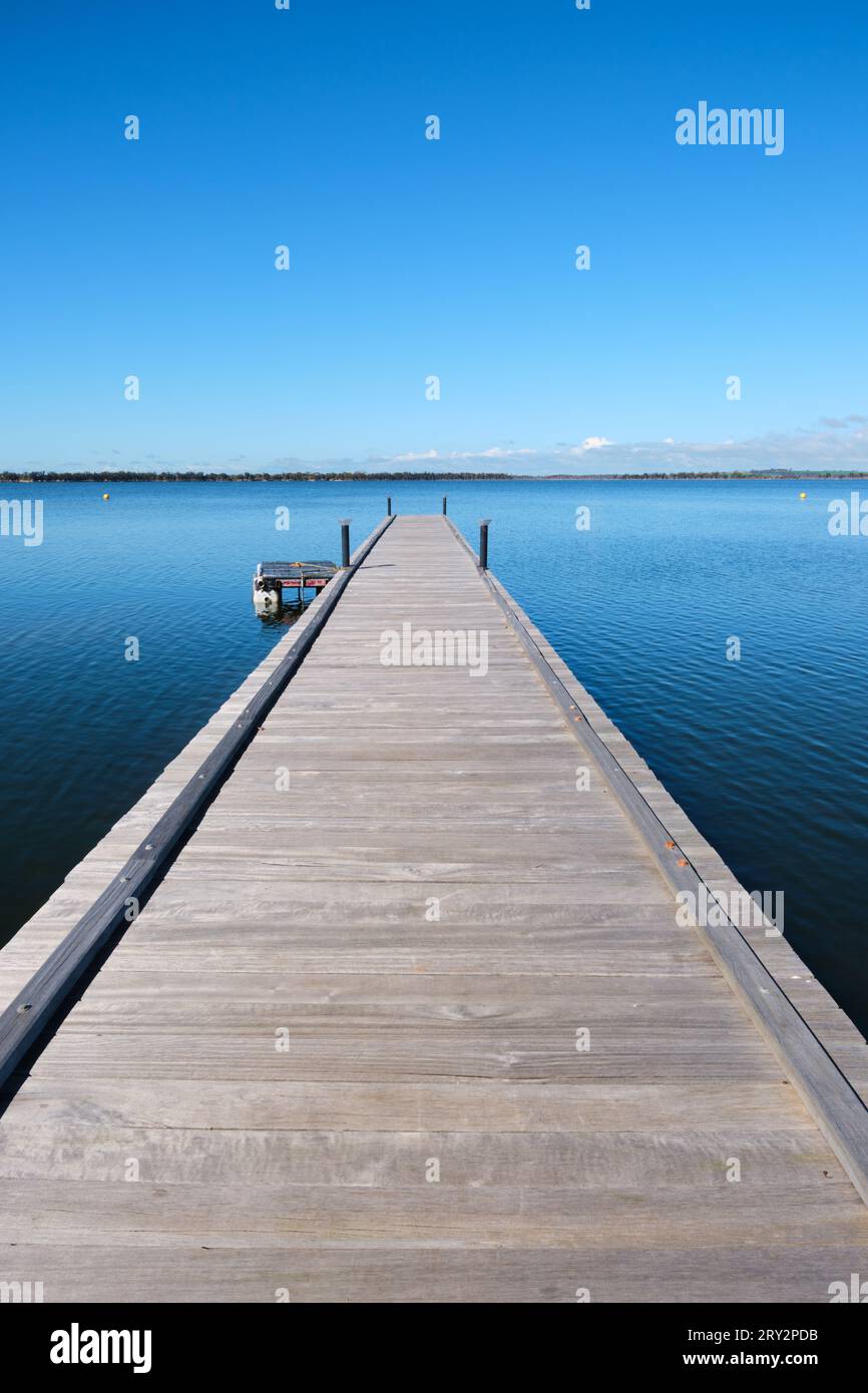 Un'immagine verticale del molo di legno presso il lago Yealering situato vicino alla cittadina di Yealering nella regione di Wheatbelt dell'Australia Occidentale. Foto Stock