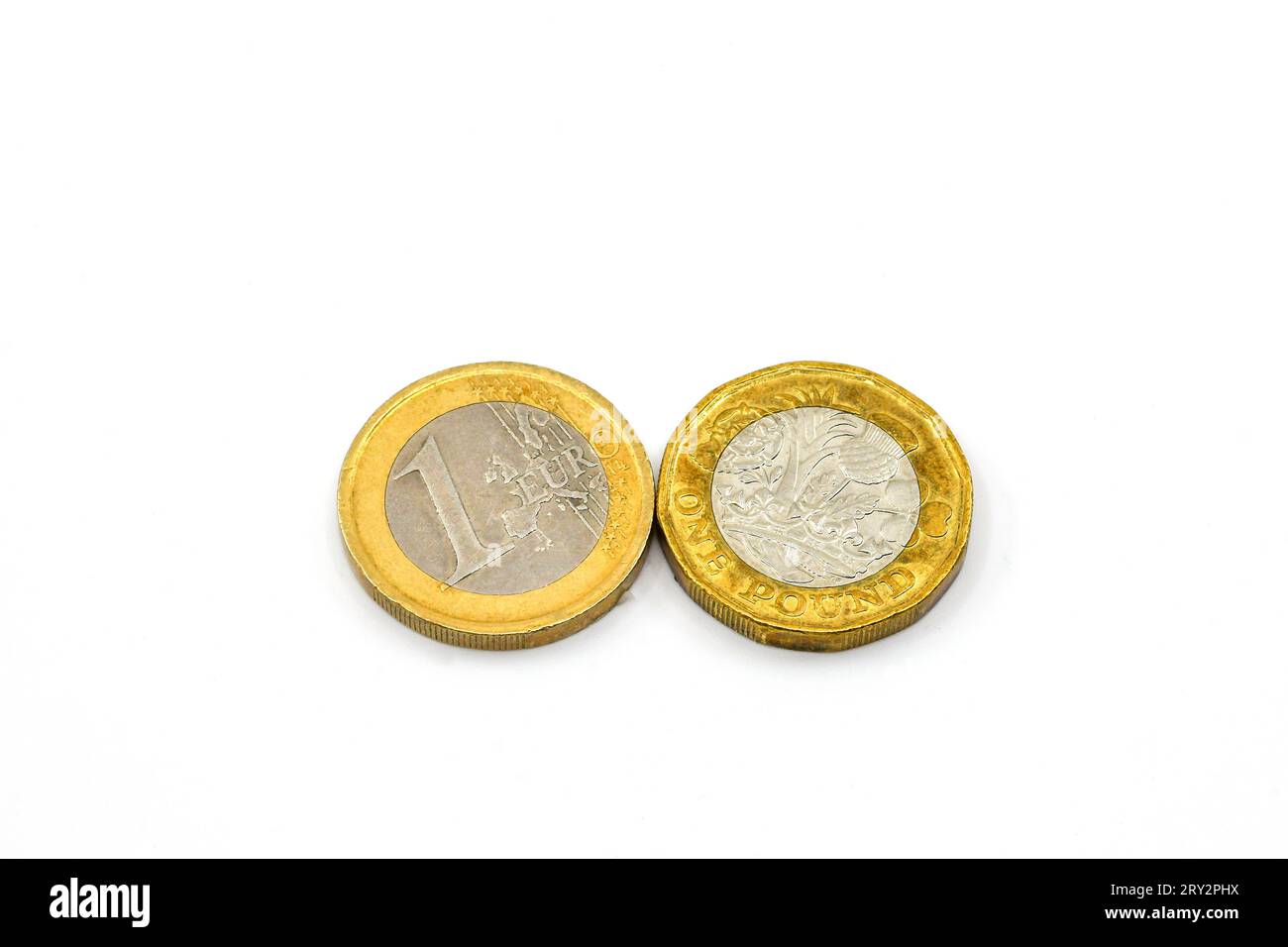 Una moneta da un euro e una moneta britannica da una sterlina isolata su un semplice sfondo bianco. Copia spazio. Foto Stock