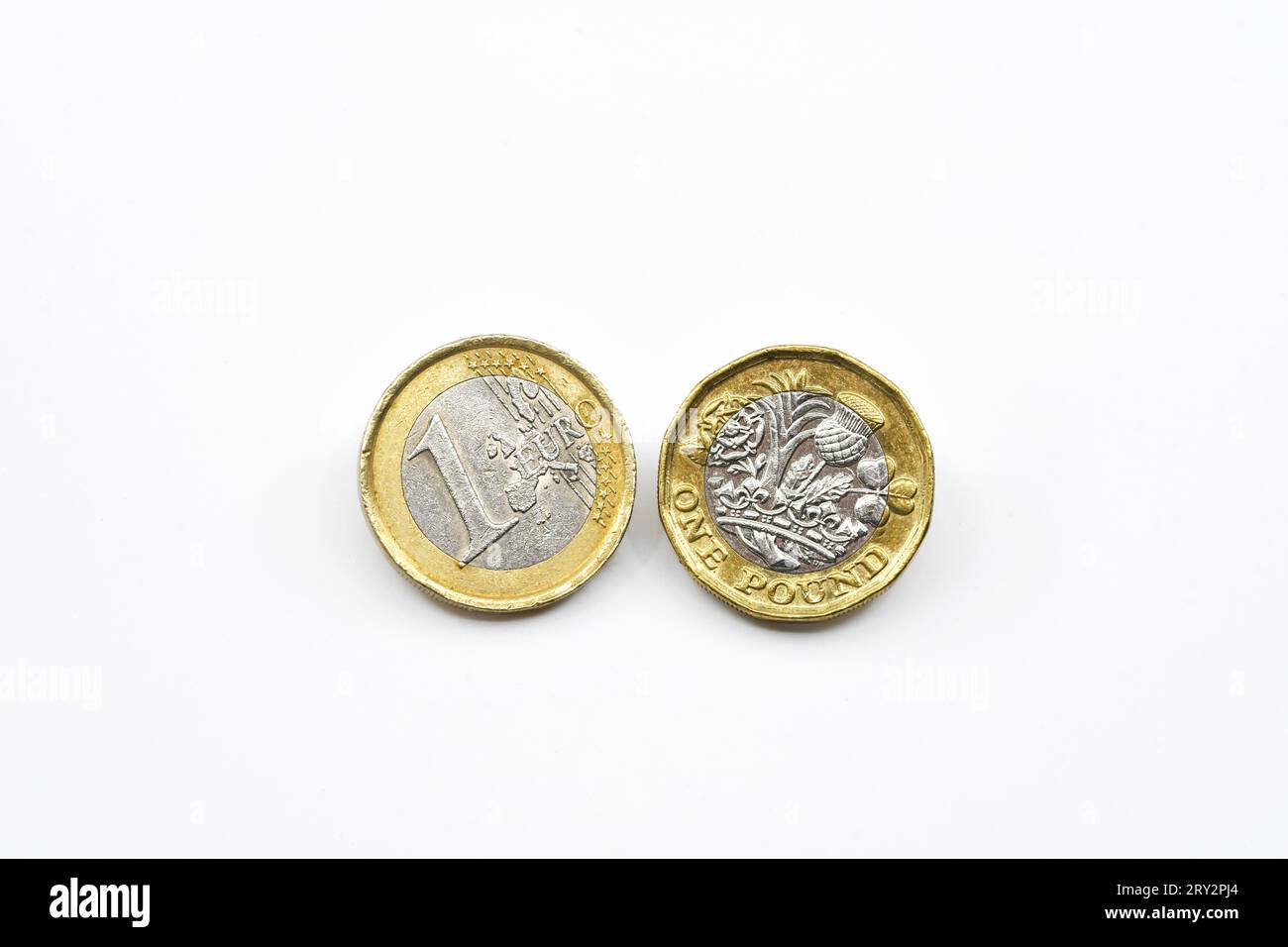 Una moneta da un euro e una moneta britannica da una sterlina isolata su un semplice sfondo bianco. Copia spazio. Foto Stock