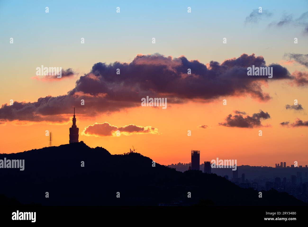 Dusk's Drama: Sunlight, Dynamic Clouds e Urban silhouette. Le silhouette della città al tramonto: Una danza di luce solare e nuvole. Foto Stock