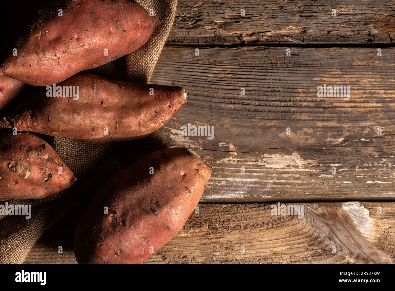 Patate dolci su un tavolo in legno rustico con spazio per copiare Foto Stock