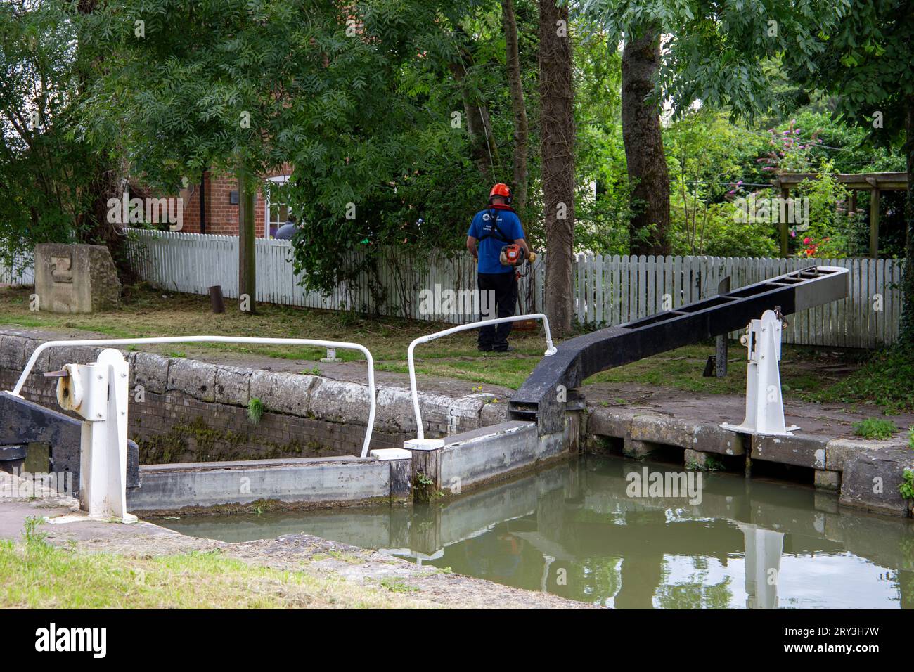Tenendo l'erba in ordine, il canale Kennet & Avon Devizes Wiltshire UK Foto Stock