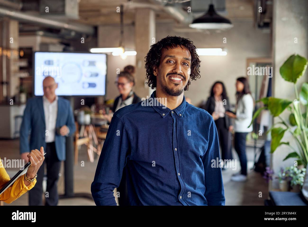 Ritratto di uomo d'affari sorridente in piedi in ufficio creativo Foto Stock