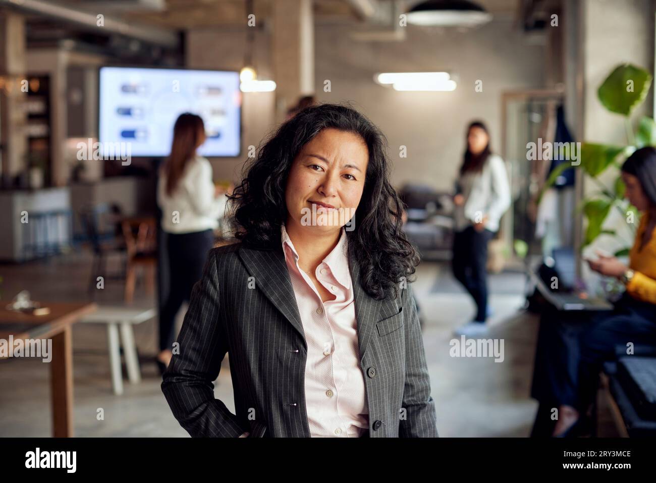 Ritratto di una donna d'affari sorridente che indossa abiti in ufficio creativo Foto Stock