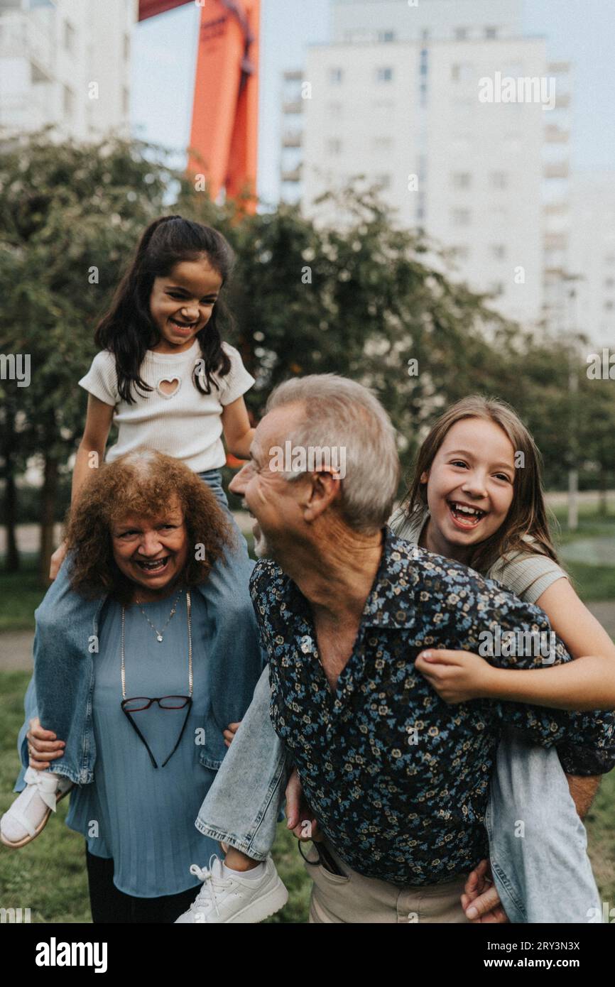 Nonni e nipoti giocosi che si divertono al parco Foto Stock