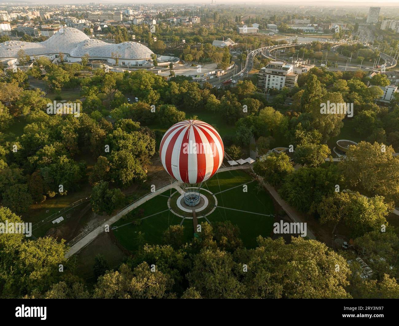 il gas rosso e bianco riempiva un enorme palloncino contro il cielo azzurro. Popolare attrazione nel parco cittadino di Budapest. luci estive. viaggi, turismo, tempo libero Foto Stock