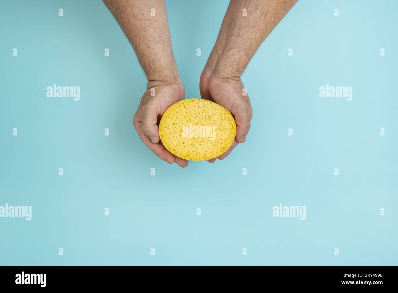 Le mani di un uomo che tiene una spugna Foto Stock