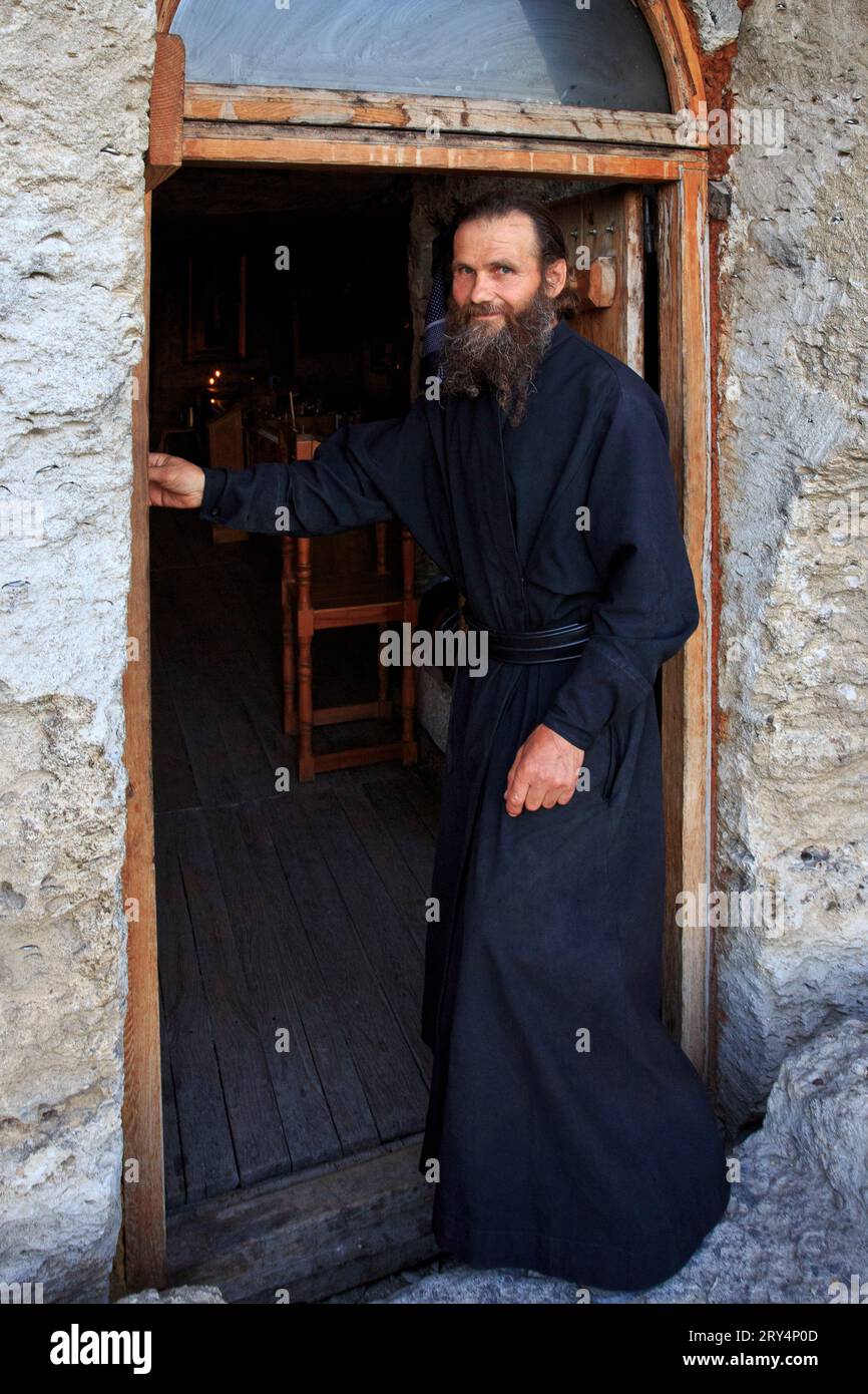 Un monaco all'ingresso posteriore del monastero della grotta Orhei (Orheiul Vechi) ortodosso orientale del XIII secolo a Butuceni, Moldavia Foto Stock