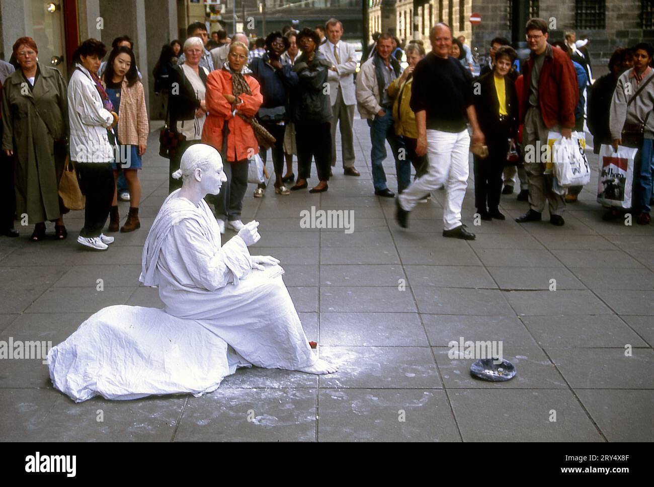L'artista di strada coperto di gesso appare come una statua immobile su una strada di Amsterdam, Olanda Foto Stock