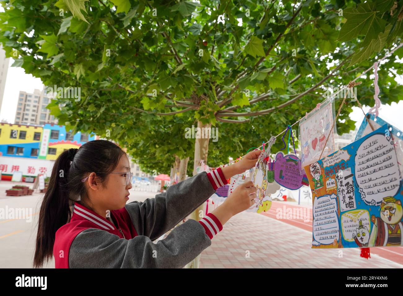 Contea di Luannan, Cina - 30 maggio 2023: Una ragazza sta impiccando una buona scheda di raccomandazione per un libro nel campus. Foto Stock
