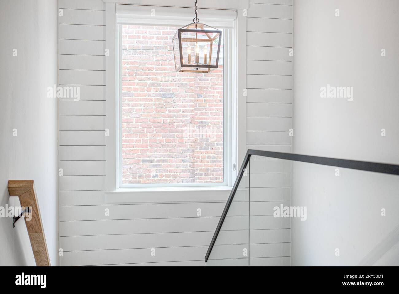 Interni puliti e moderni della scala della fattoria con muro di Shiplap e vista del muro di mattoni esposti Foto Stock