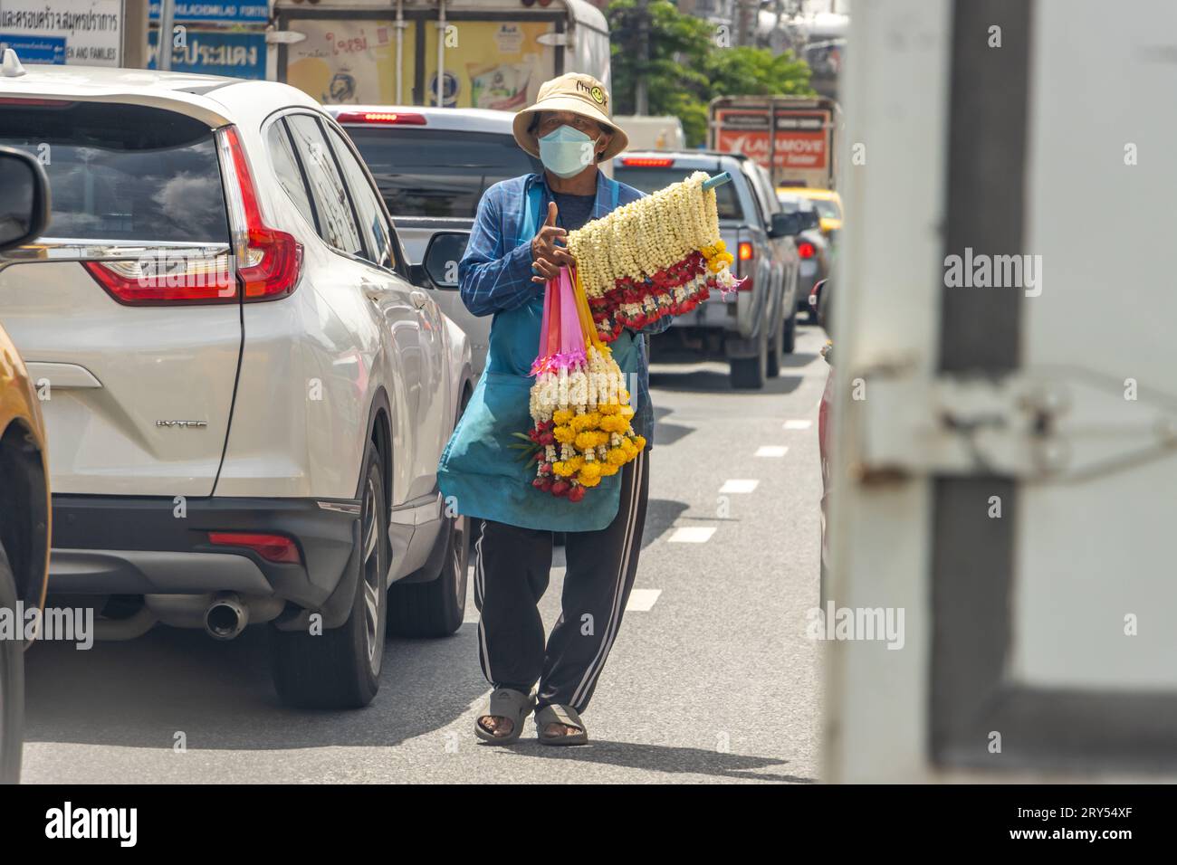 SAMUT PRAKAN, THAILANDIA, 19 settembre 2023, il venditore offre ghirlande di fiori alle auto che si trovano all'incrocio Foto Stock