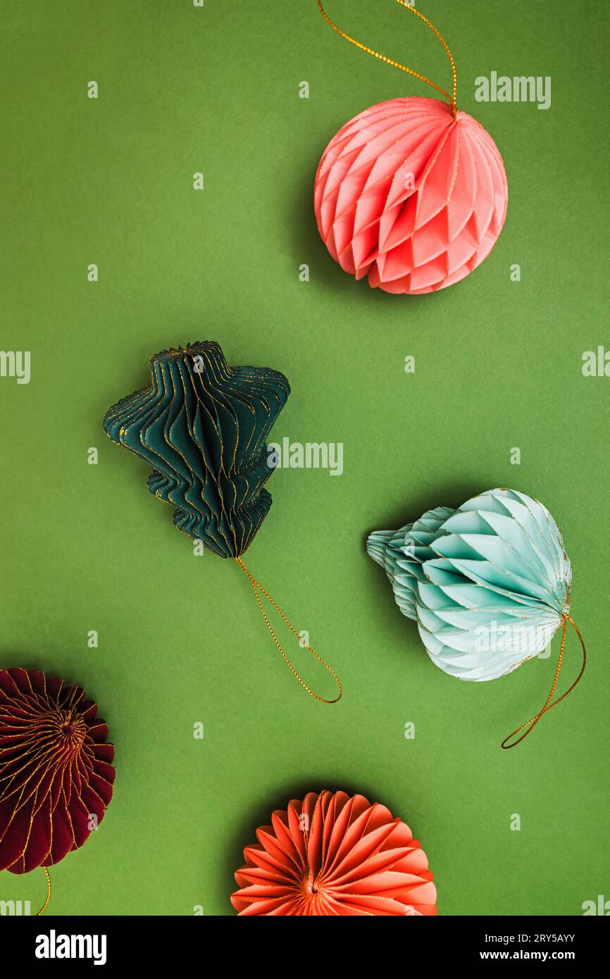 Decorazioni natalizie scandinave, decorazioni natalizie in carta a nido d'ape su sfondo verde Foto Stock