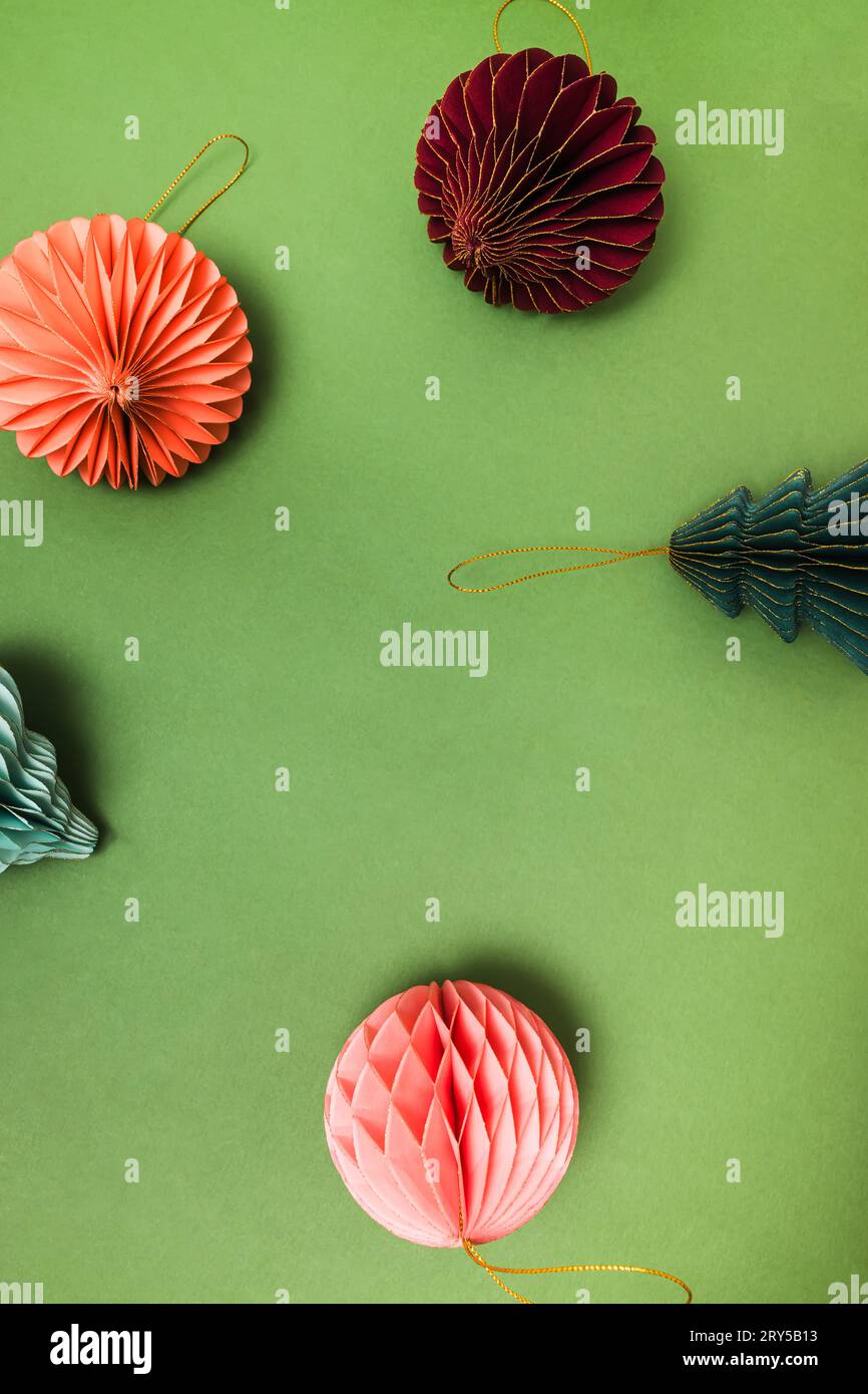 Decorazioni natalizie scandinave, decorazioni natalizie in carta a nido d'ape su sfondo verde, vista dall'alto Foto Stock
