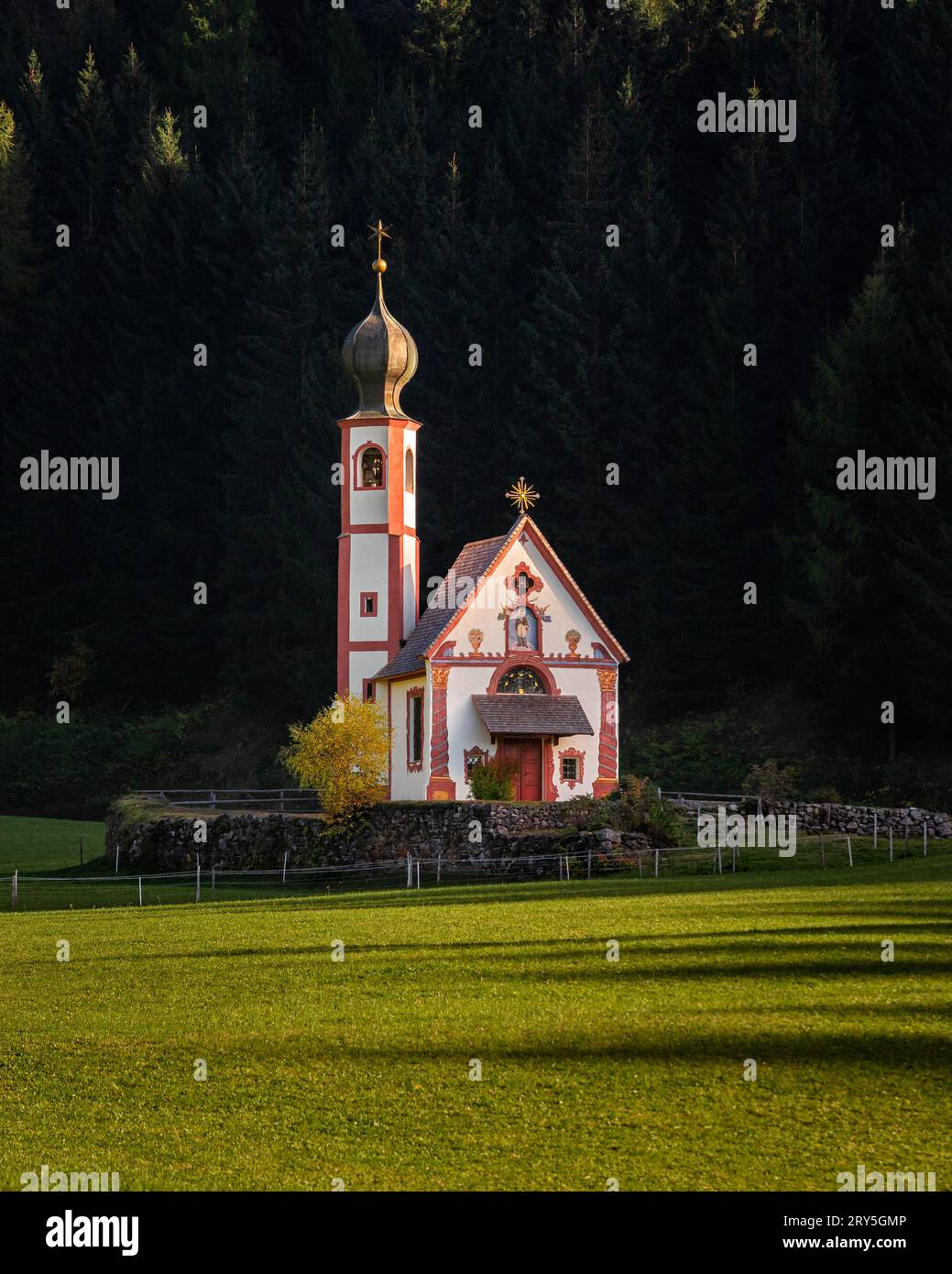 Val di Funes, Dolomiti, Italia - la splendida St Chiesa di Johann in Ranui in alto Adige nelle Dolomiti italiane con calde luci autunnali al tramonto e g Foto Stock