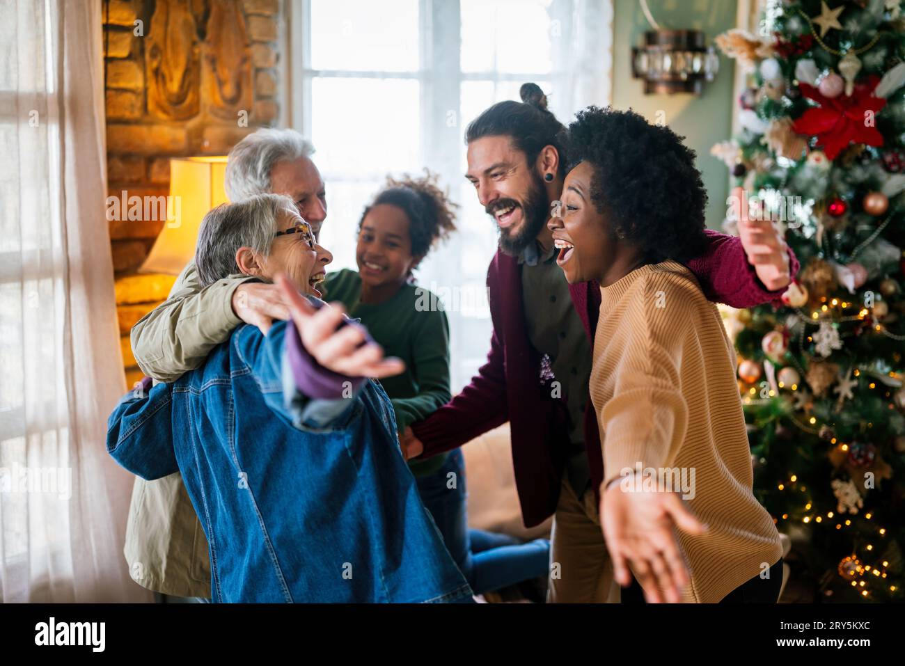Eccitato saluto multietnico dei nonni il giorno di Natale. Famiglia felice multi-generazionale Foto Stock