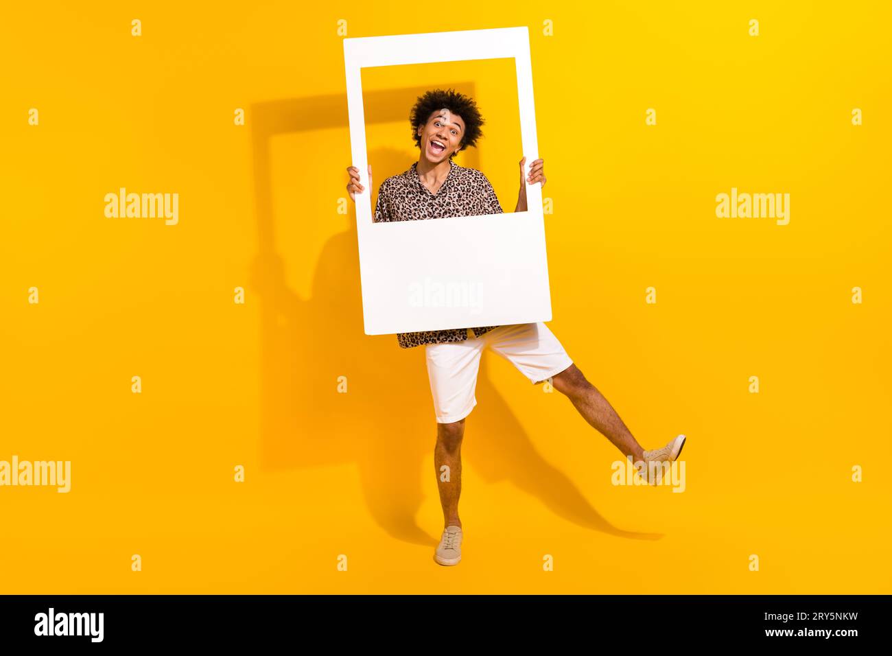 Foto a grandezza naturale di una persona eccentrica e infantile che indossa una camicia leopardata pantaloncini bianchi che si ingannano in una cornice isolata su sfondo di colore giallo Foto Stock