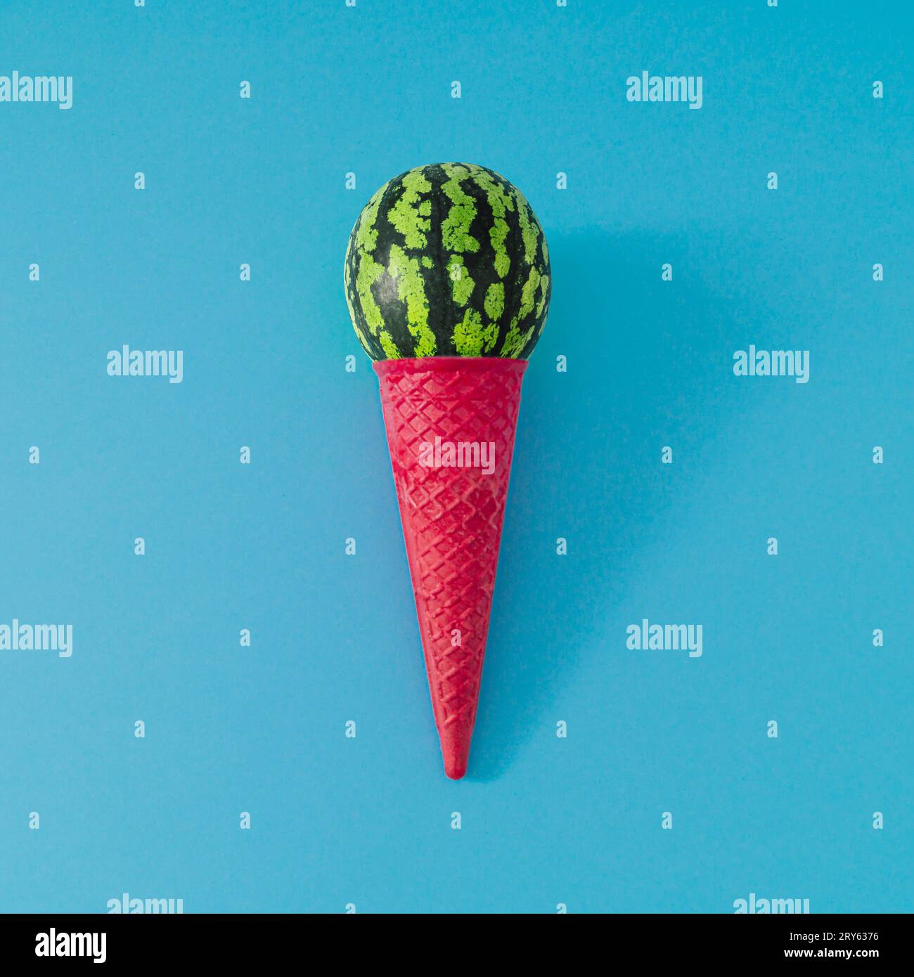 Gelato a base di cono gelato con waffle rosa e paletta di frutta anguria su sfondo azzurro. Composizione del gelato estivo. Concetto minimo. Foto Stock