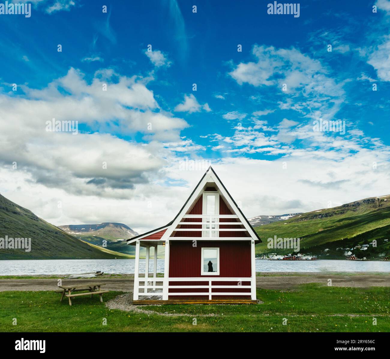 Bordo rosso della cabina del fiordo nella verde valle con riflesso blu delle donne del cielo Foto Stock