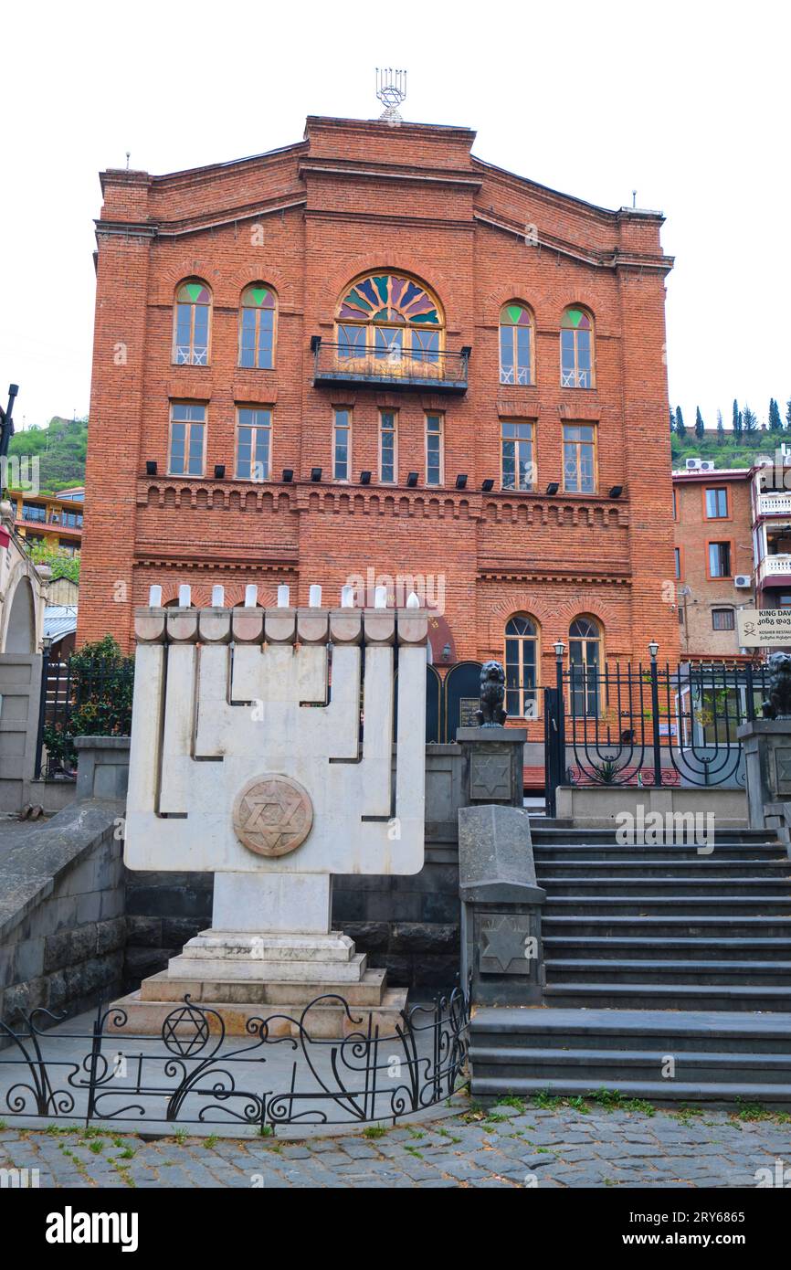 Vista esterna con grande menorah bianca in pietra e marmo. Presso la grande sinagoga ebraica di mattoni rossi a Tbilisi, Georgia, Europa. Foto Stock