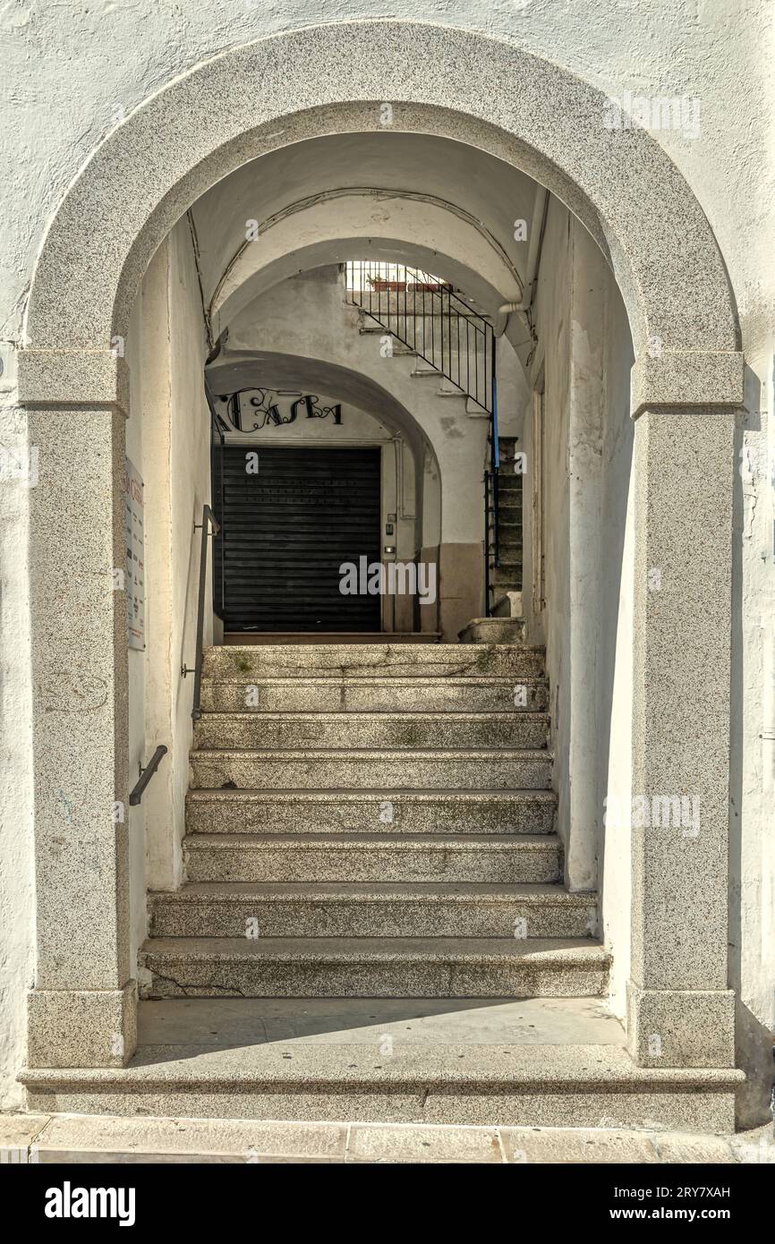 Cortile interno di un palazzo nobiliare con accesso da un passaggio coperto con gradini e portici. Monte Sant'Angelo, provincia di Foggia, Italia, Europa Foto Stock