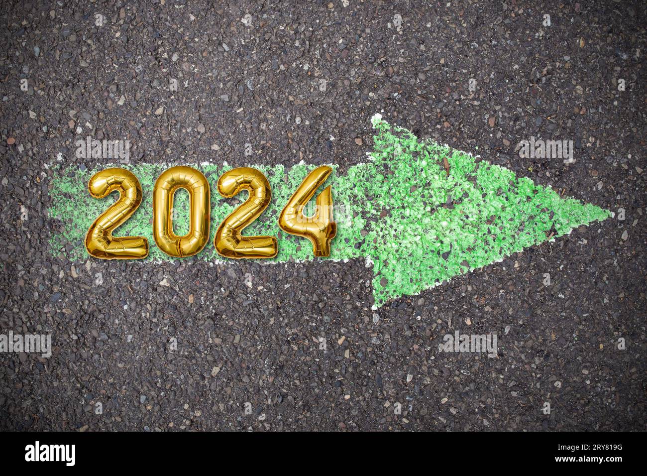 Freccia verde dipinta su asfalto, texture grunge asfalto con numeri oro 2024, segno di Capodanno Foto Stock