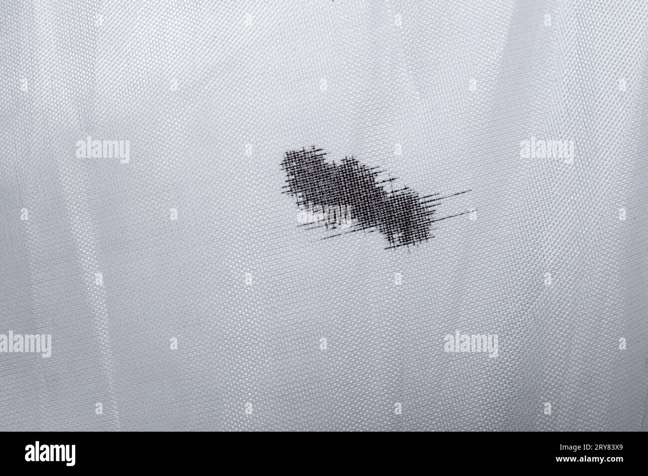 Macchie di inchiostro nero su tessuto in fibra sintetica bianca Foto Stock