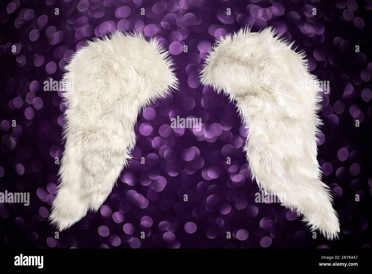 due ali di pelliccia bianca isolate su sfondo viola con palle di bokeh, elemento da mockup natalizio Foto Stock