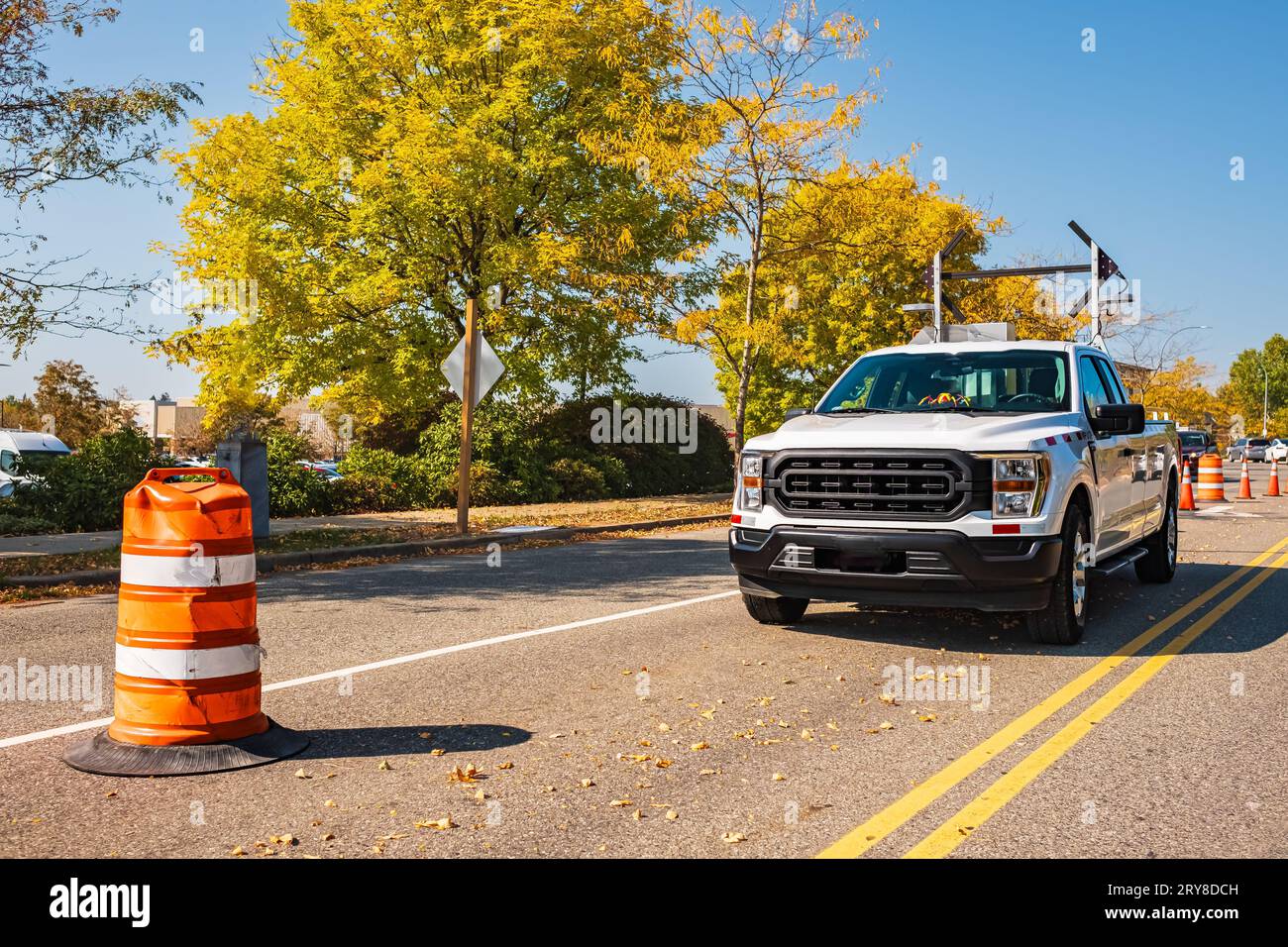 Le luci di segnalazione per la riparazione su strada lampeggiano e si deviano con il limite di velocità su un carrello per la manutenzione. I semafori direzionali portatili sono stati montati su t Foto Stock