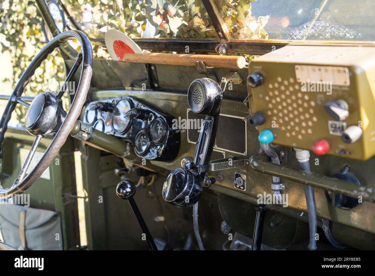 Interno di una vecchia jeep militare verde coperta da rete mimetica Foto Stock